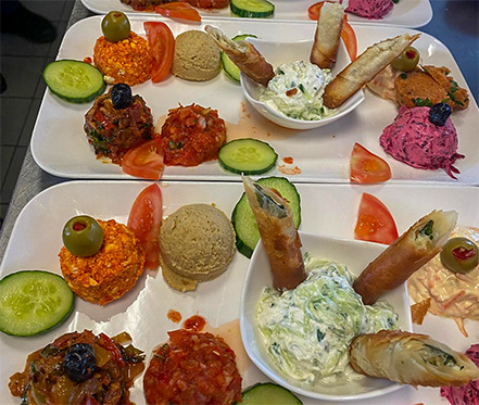 Auswahl an traditionellen türkischen Vorspeisen mit Haydari, Hummus, Sigara Börek und Acılı Ezme auf einem weißen Teller.