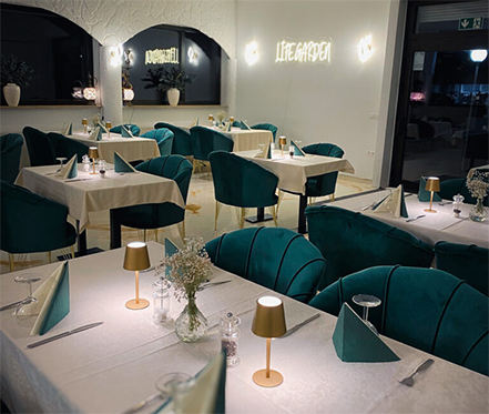 Innenansicht des Life Garden Restaurants mit festlich gedeckten Tischen für Events.